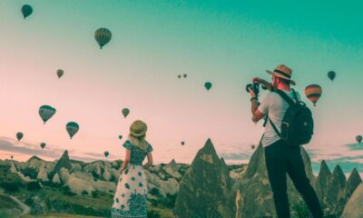 man taking photo of hot air balloons