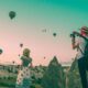 man taking photo of hot air balloons