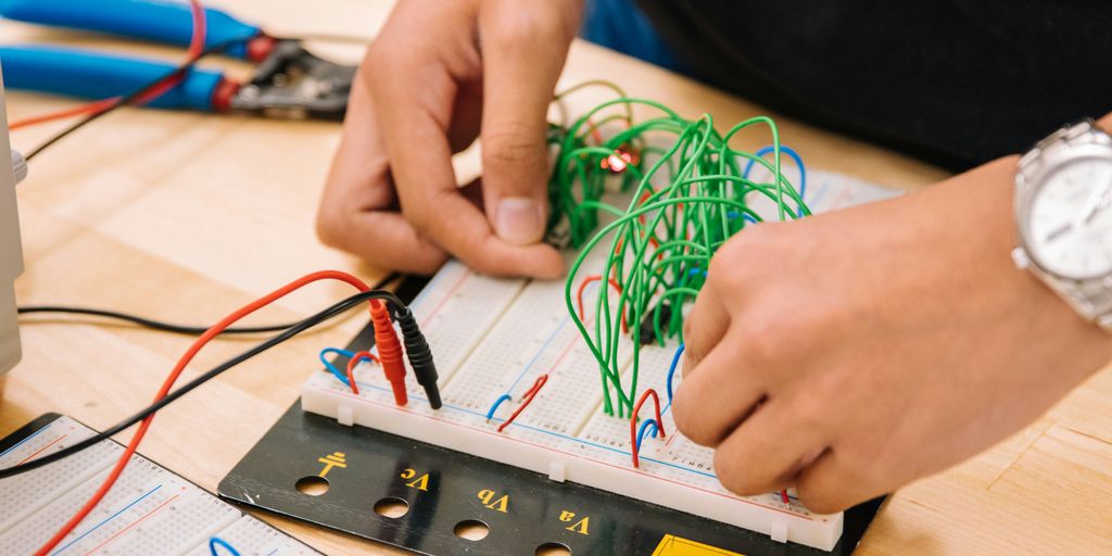 person holding black and white audio mixer