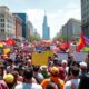 Crowd of diverse protesters in an urban setting.