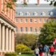 Harvard University campus with students and international flags.