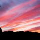 silhouette of man standing on high ground under red and blue skies