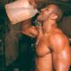 topless man drinking water from plastic container