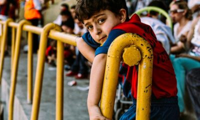 boy in blue and red shirt holding yellow metal bar