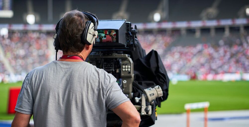 a man with headphones on sitting in front of a camera