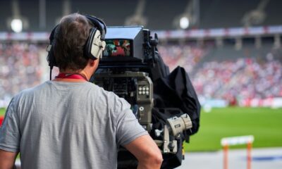 a man with headphones on sitting in front of a camera