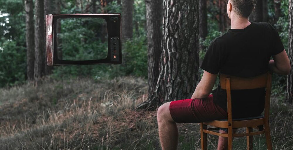 man in black t-shirt sitting on brown wooden chair