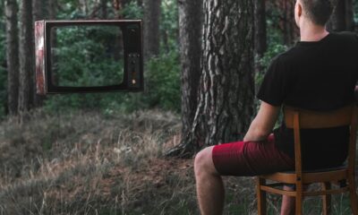 man in black t-shirt sitting on brown wooden chair