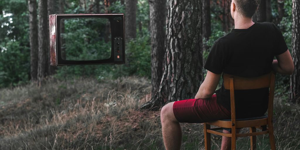 man in black t-shirt sitting on brown wooden chair