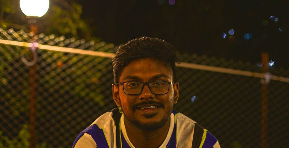 man in black and yellow jersey shirt smiling