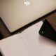 silver macbook beside black iphone 5