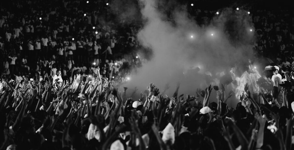 a black and white photo of a crowd at a concert