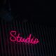 a neon sign that reads studio on the side of a building