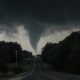 a large tornado is seen in the sky over a road