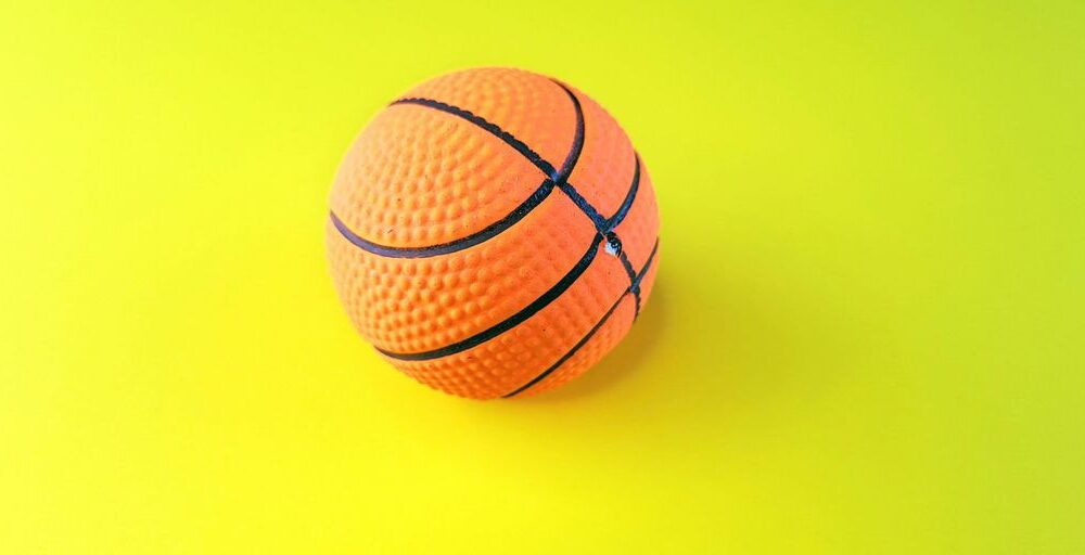an orange and black basketball on a yellow and green background
