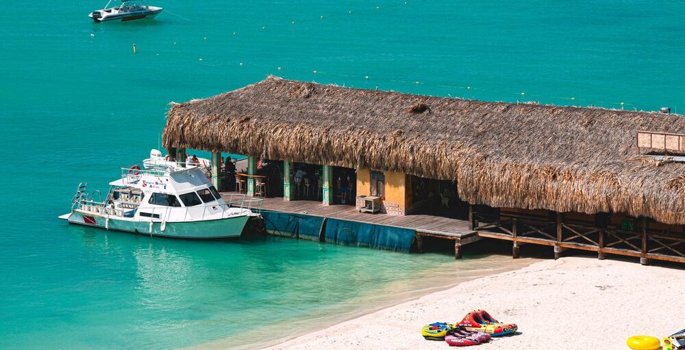 white motor boat beside hut