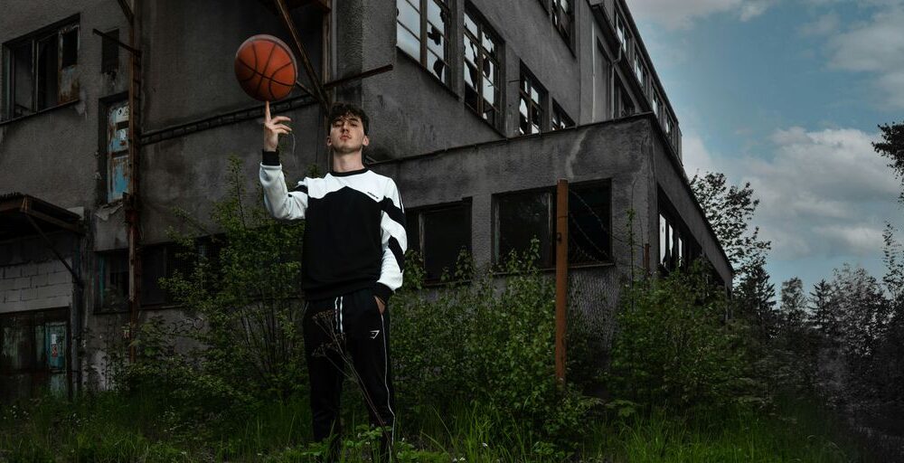 a man holding a basketball in front of a building