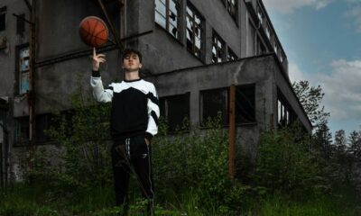 a man holding a basketball in front of a building