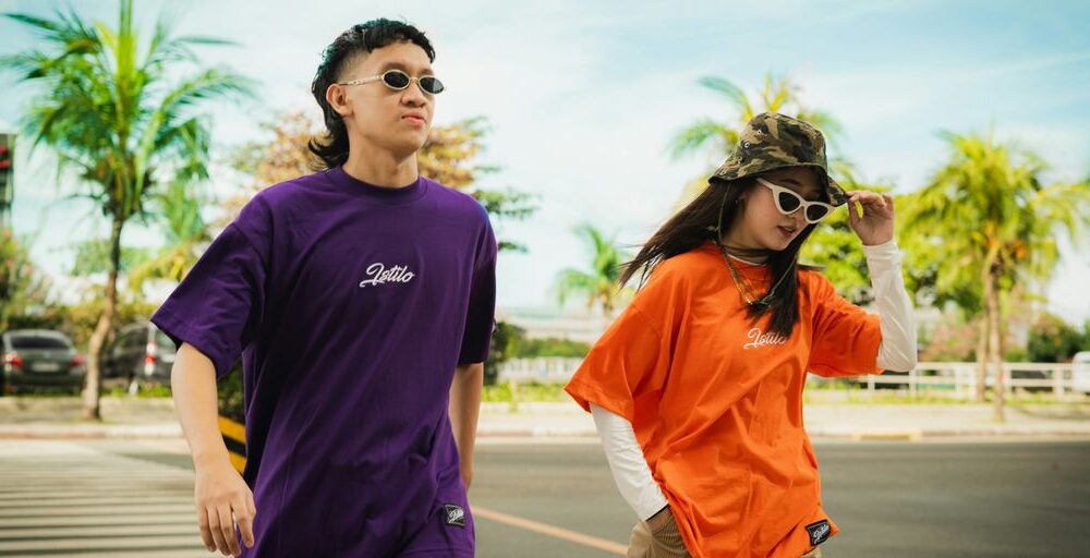 man in black crew neck t-shirt standing beside woman in orange crew neck t-shirt