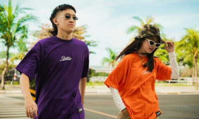 man in black crew neck t-shirt standing beside woman in orange crew neck t-shirt