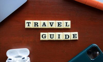 a wooden table topped with a cell phone and ear buds