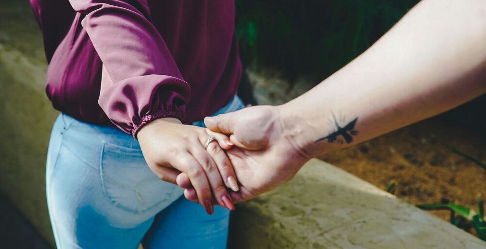 couple holding hands during daytime
