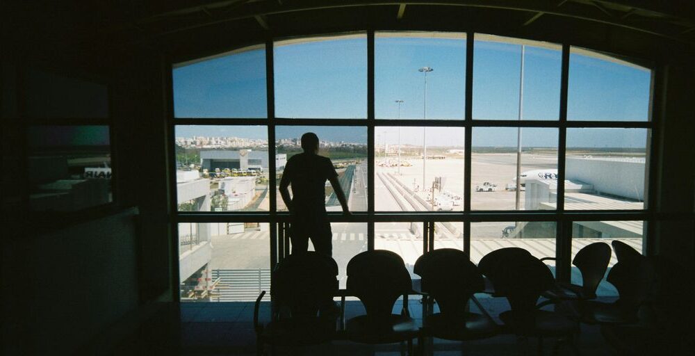 silhouette of man standing near glass window