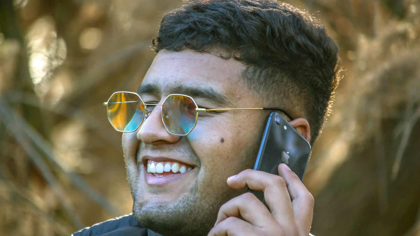 a man wearing sunglasses talking on a cell phone