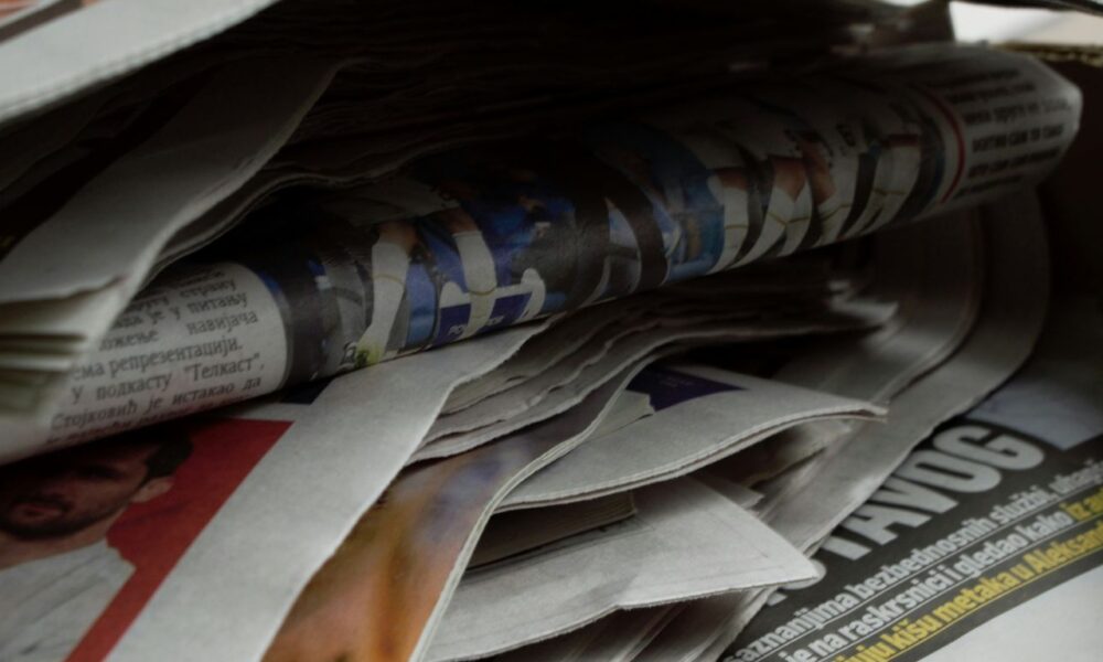 a bunch of newspapers stacked on top of each other